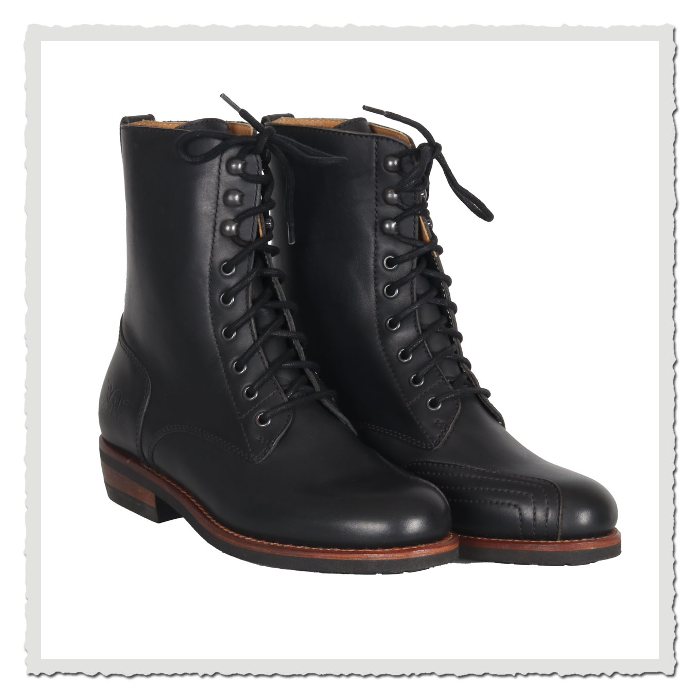 Schwarzes Paar Schnürboots in leichter Seitenansicht, freigestellt auf neutralem hellem Grund.